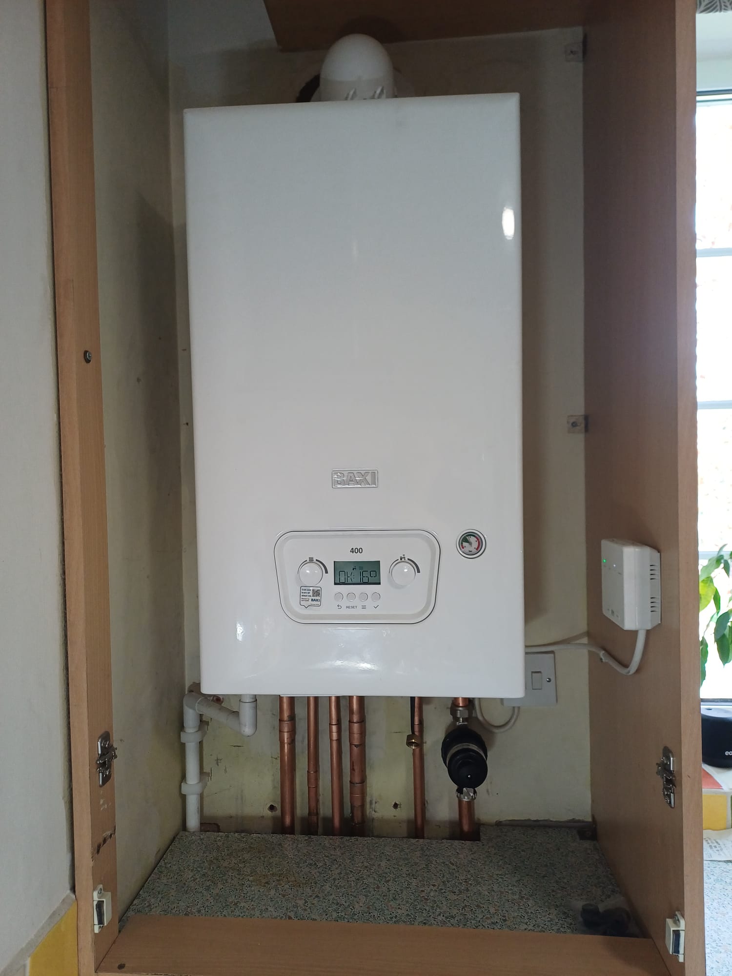 Baxi boiler fitted in a cupboard with copper pipework below