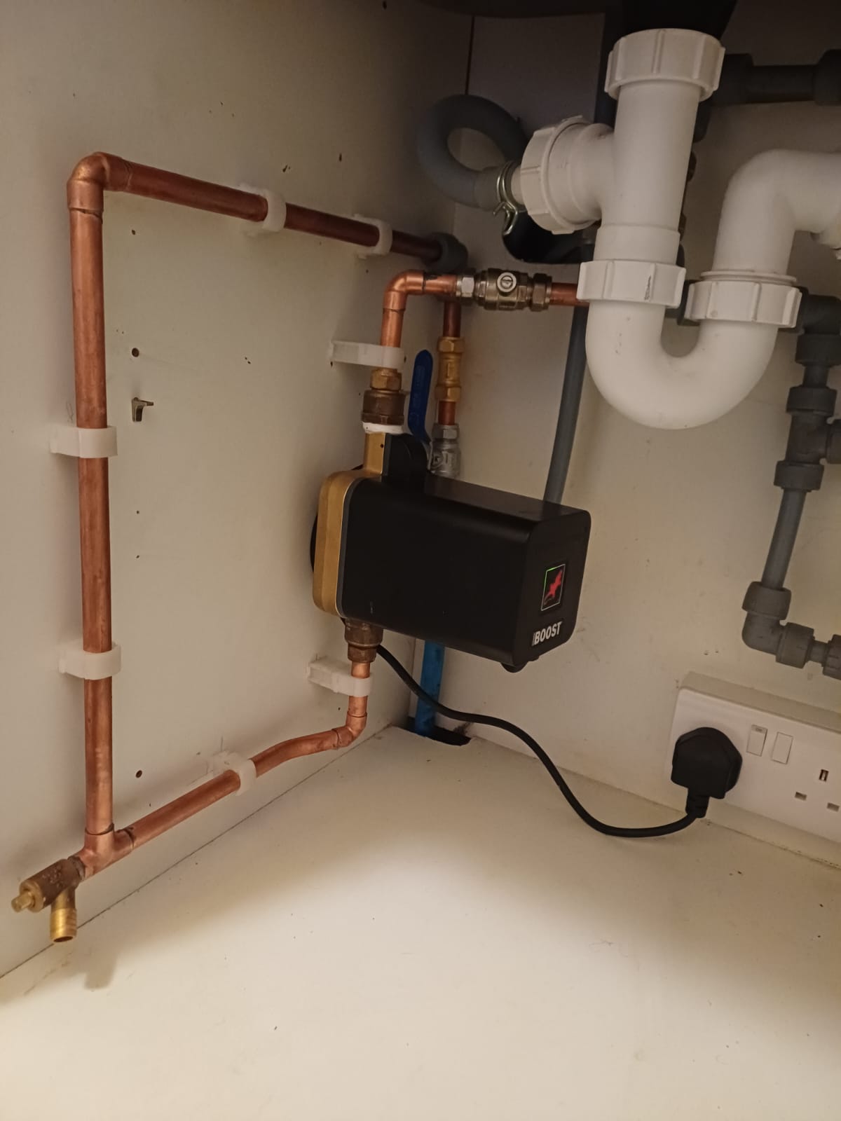 Pump and copper pipework neatly fitted beneath a sink